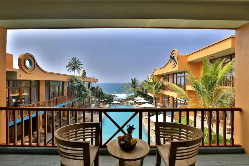 Vue d'une terrasse sur une piscine et la mer.