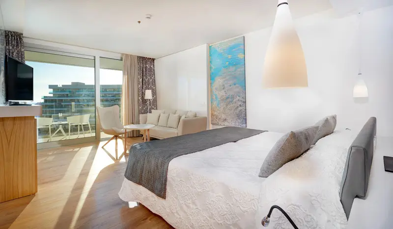 Une chambre lumineuse avec un grand lit et un accès à une terrasse.
