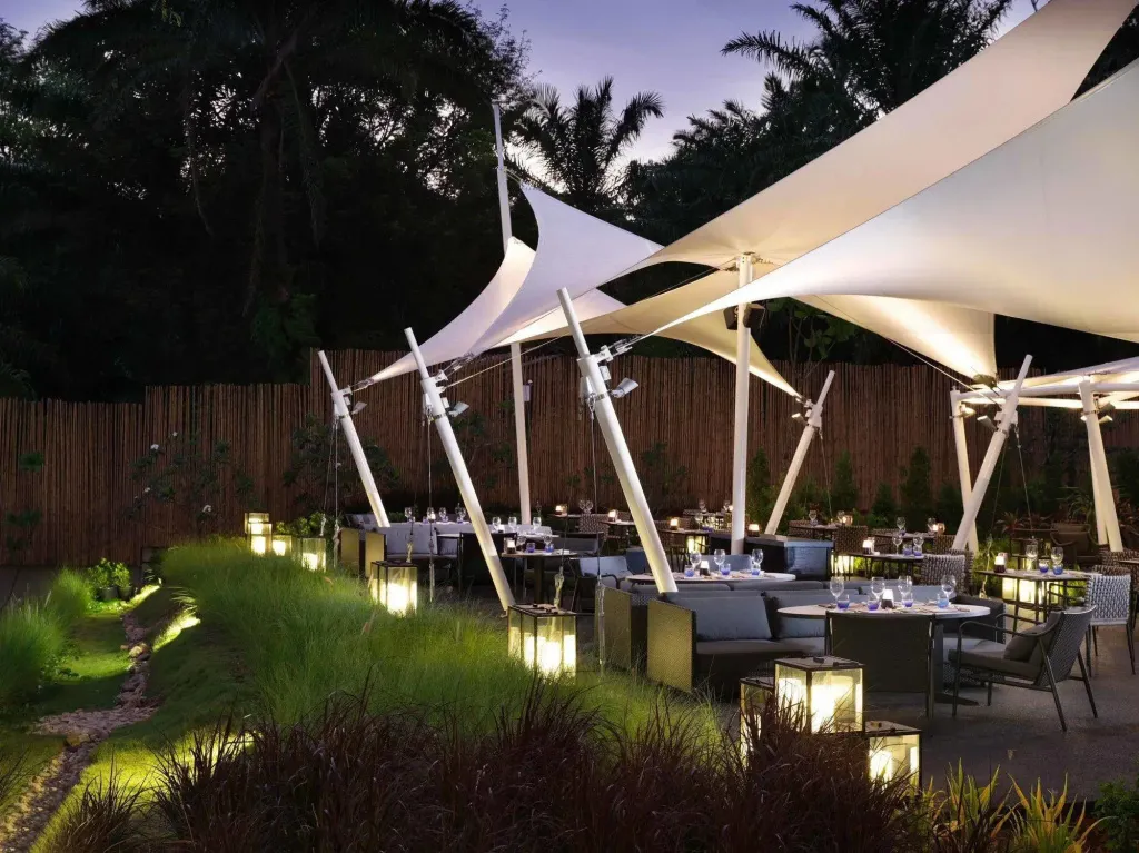 Terrasse lumineuse avec tables dressées pour le dîner.