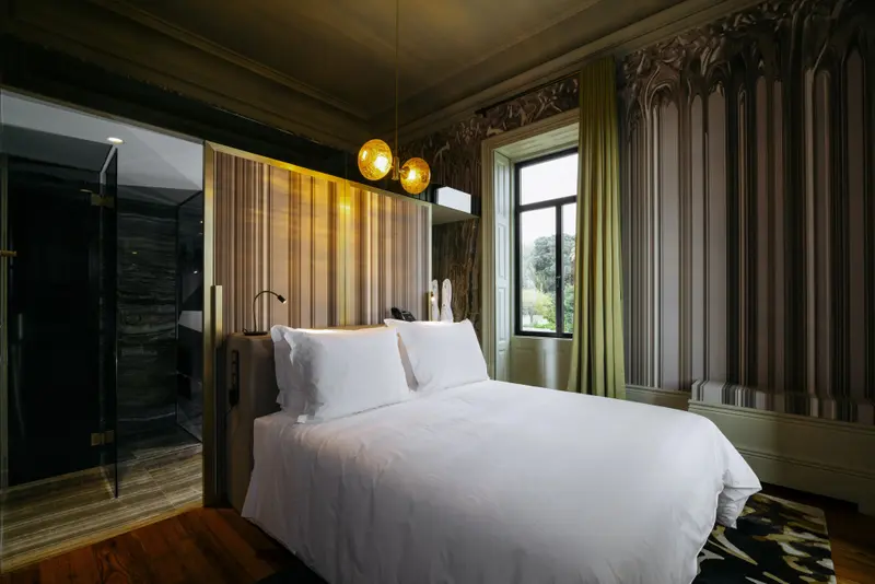 Une chambre lumineuse avec un grand lit recouvert de linge blanc.