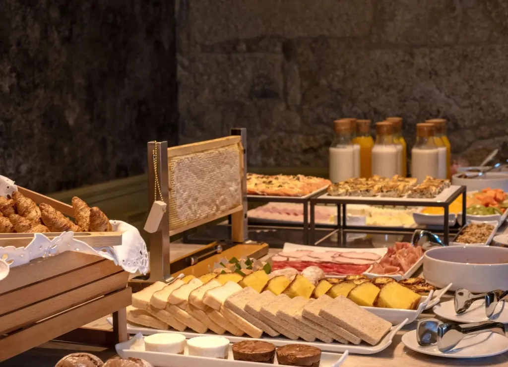 Un buffet propose une selection de viennoiseries, de charcuteries et de fromages.