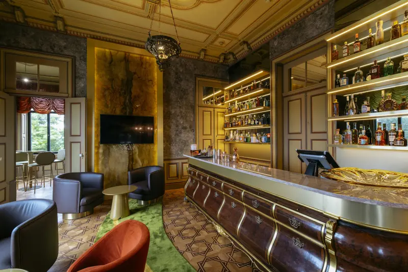 Un bar élégant avec un comptoir en marbre et des fauteuils confortables.