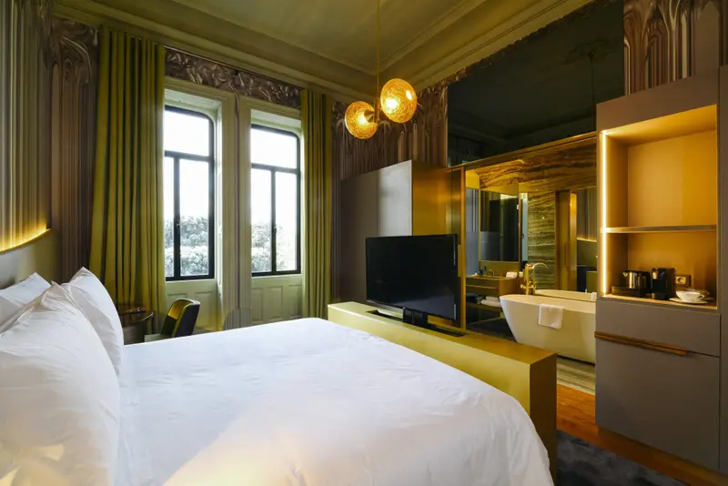 Une chambre lumineuse avec un grand lit et une baignoire design.