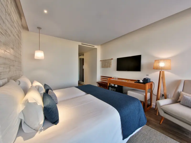 Une chambre lumineuse avec un grand lit et un espace bureau.