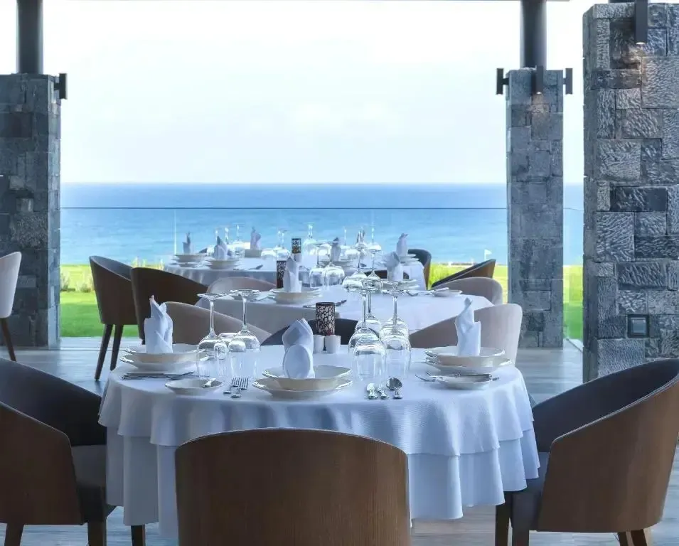 Une table dressée en salle à manger offre une vue sur la mer.