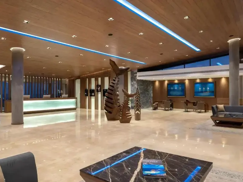 Vaste hall d'accueil moderne avec un comptoir et des éléments décoratifs en bois.