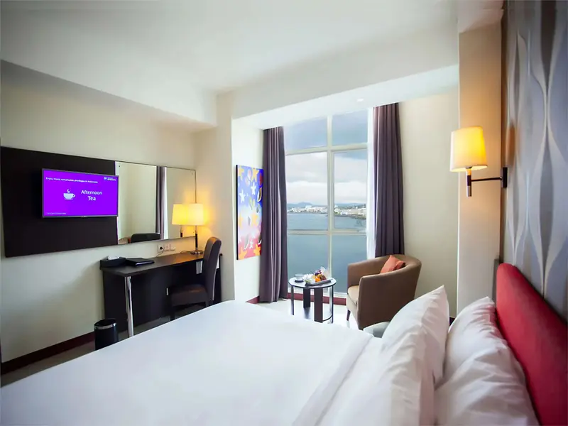 Une chambre lumineuse avec un grand lit et une vue sur la mer.