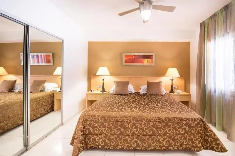 Une chambre d'hôtel avec un grand lit et des miroirs.