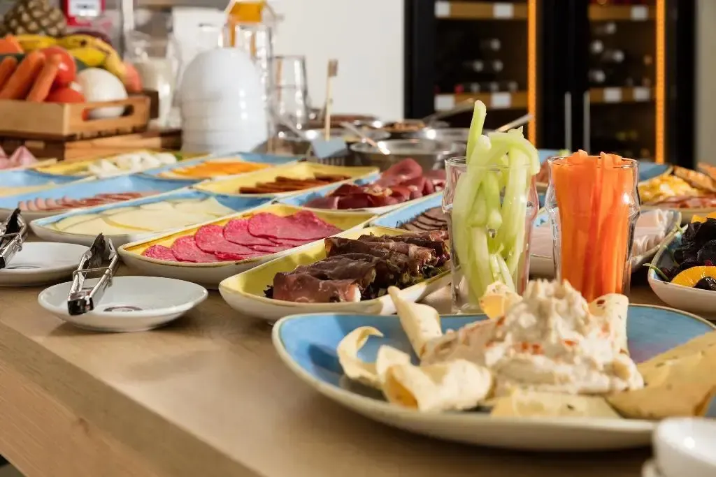 Une table garnie de divers plats et de crudités.