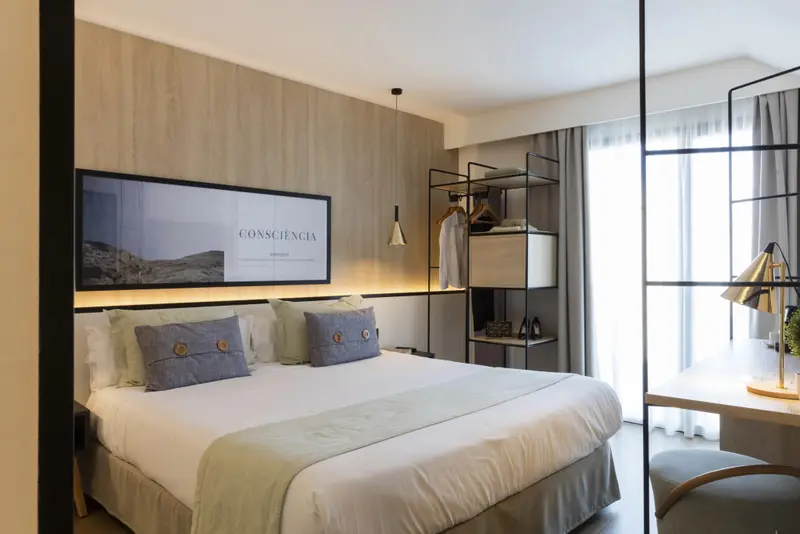 Une chambre lumineuse avec un grand lit et un espace bureau.