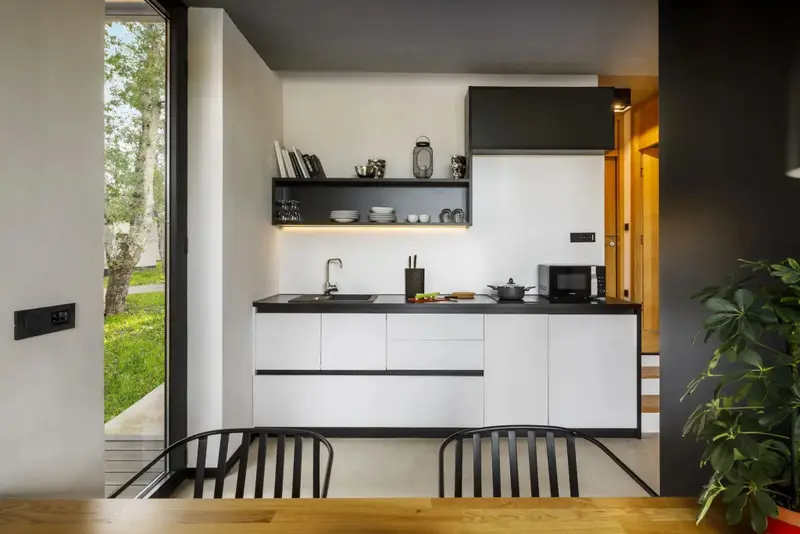 Une cuisine moderne s'ouvre sur un espace extérieur verdoyant.
