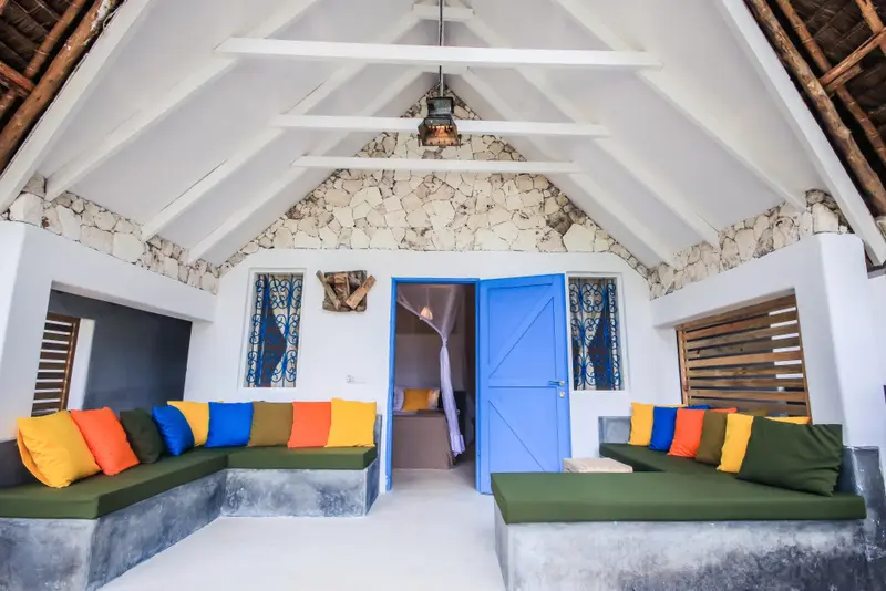 Espace de détente intérieur avec assises colorées et moucharabihs.