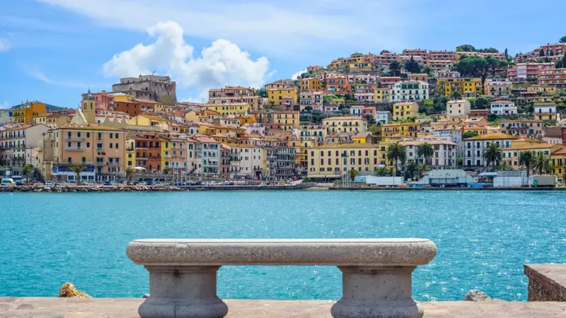 Vue d'une ville colorée sur une colline surplombant un port de plaisance.
