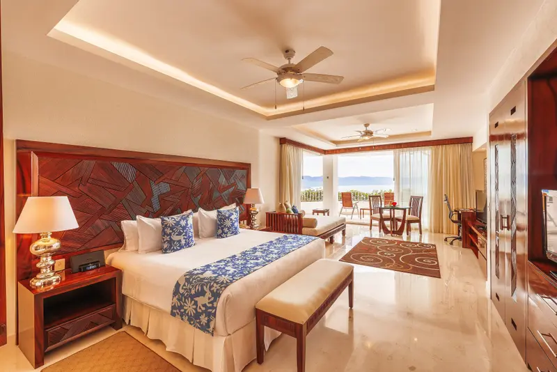 Une chambre spacieuse et lumineuse avec un grand lit et un espace repas.