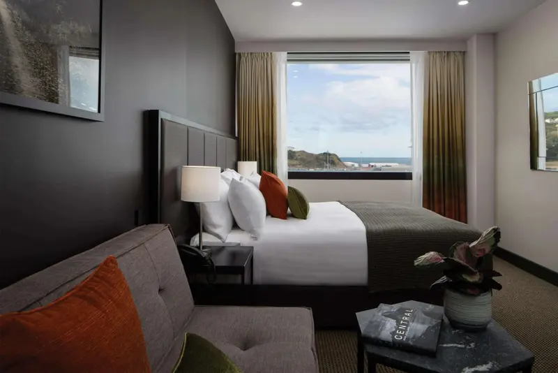 Une chambre lumineuse avec un grand lit et une vue sur la mer.