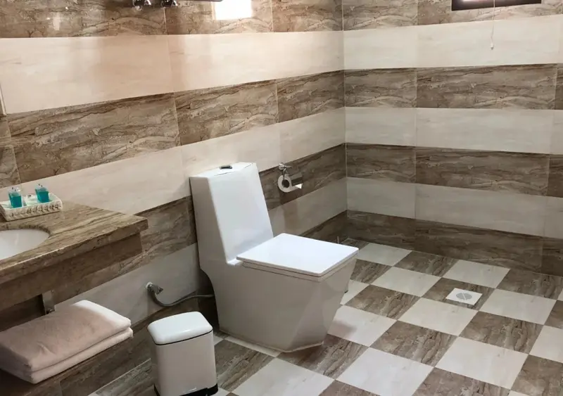 Une salle de bain moderne avec carrelage beige et blanc.