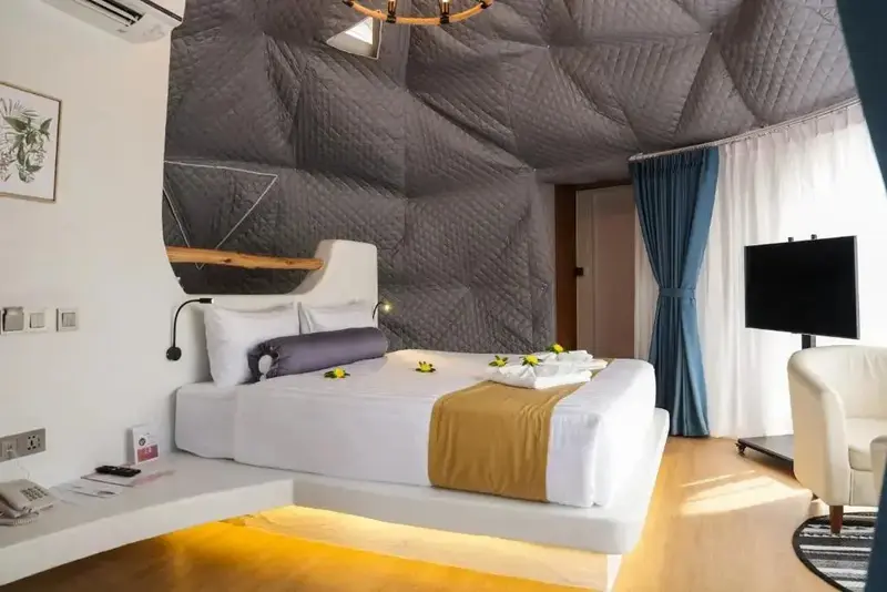 Une chambre lumineuse avec un lit grand format et une décoration moderne.
