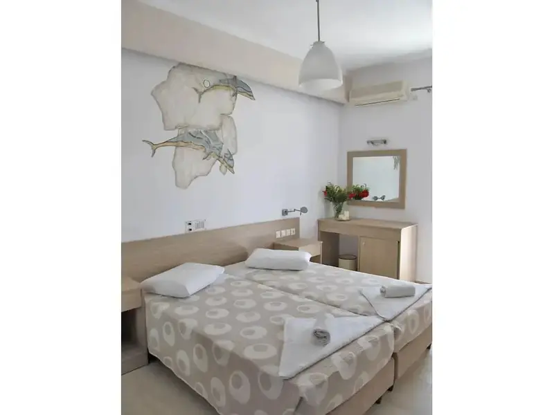 Une chambre lumineuse avec un grand lit décoré de motifs marins.