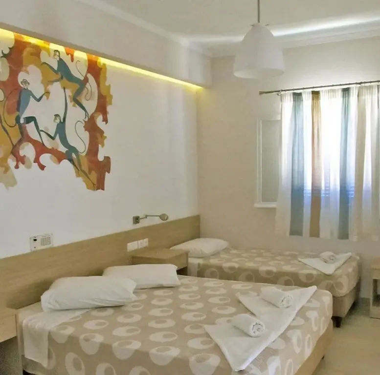 Une chambre lumineuse avec deux lits et une décoration murale colorée.