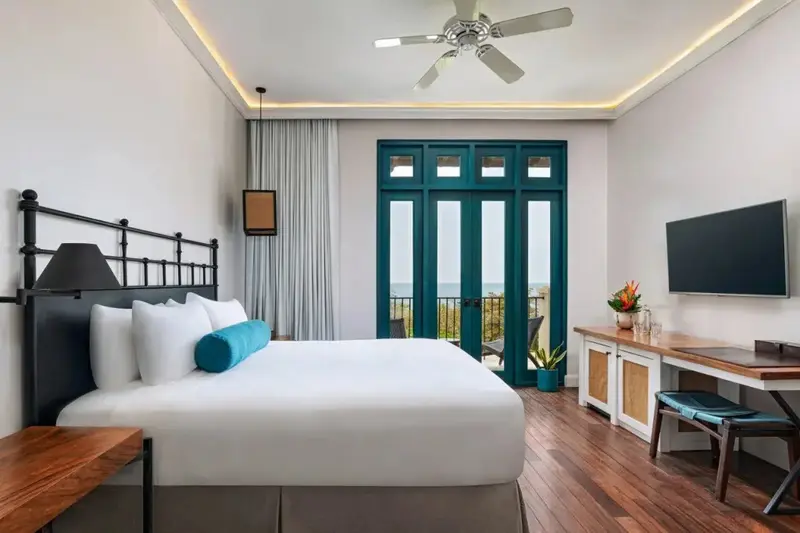 Une chambre lumineuse avec un grand lit et un accès à une terrasse.