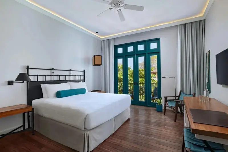 Une chambre lumineuse avec un grand lit et un bureau.