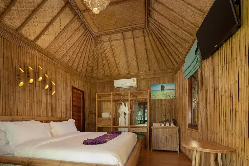 Chambre lumineuse avec lit double et décoration en bambou.