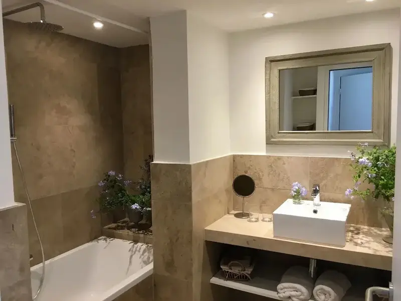 Une salle de bain lumineuse avec baignoire et douche à l'italienne.