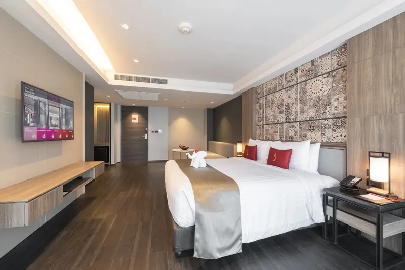 Une chambre moderne avec un grand lit et un téléviseur mural.