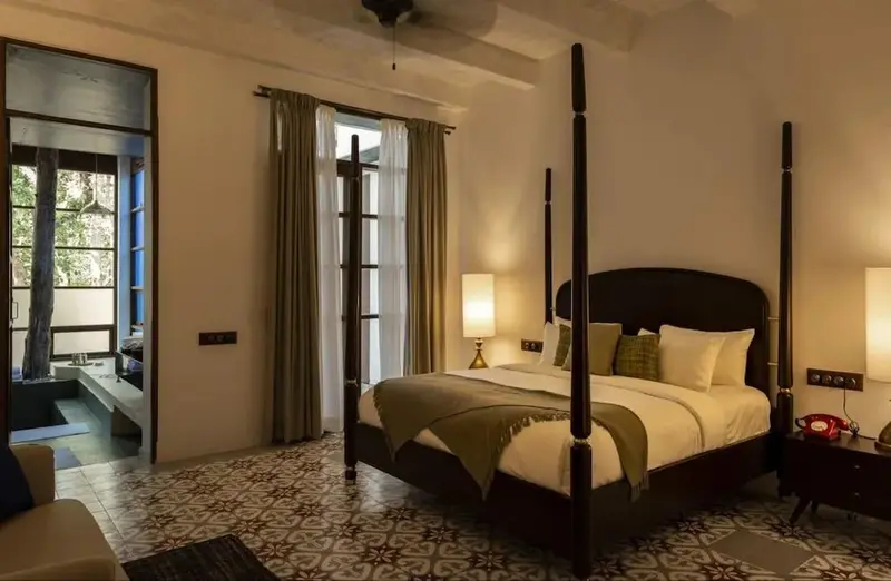 Une chambre à coucher lumineuse avec un grand lit à baldaquin et un carrelage décoratif.