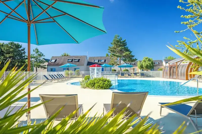 Deux transats invitent à la détente au bord d'une piscine ensoleillée.