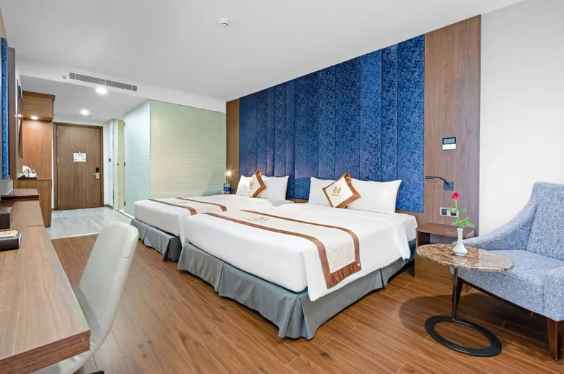 Une chambre lumineuse avec deux lits simples et un coin salon.