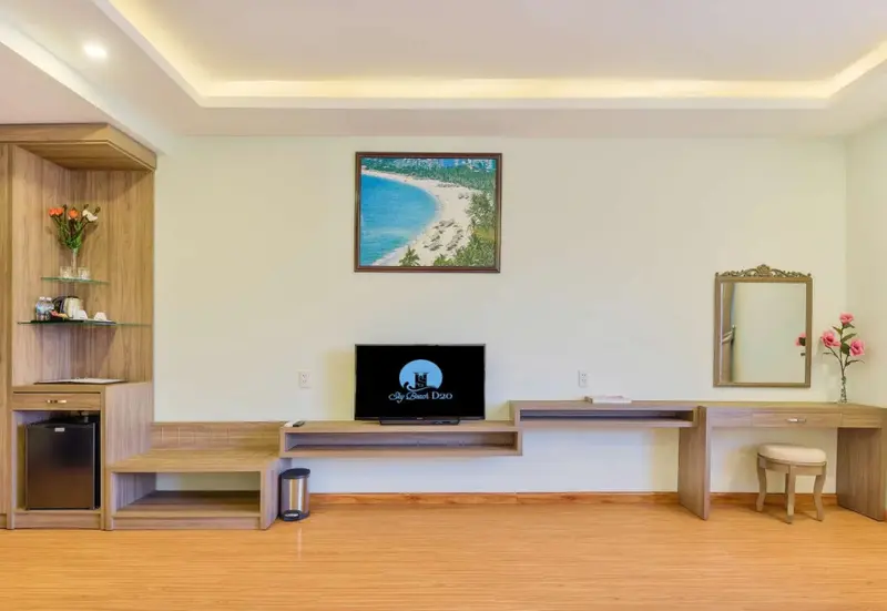 Une pièce lumineuse avec un téléviseur, un bureau et un espace de rangement.