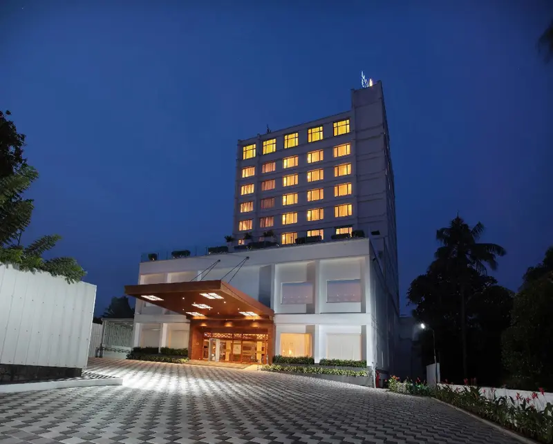 Façade d'un bâtiment moderne illuminé au crépuscule.