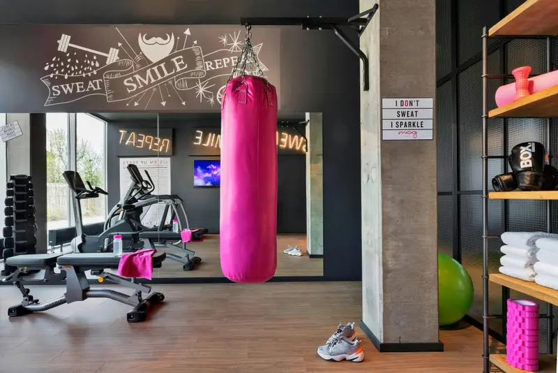Une salle de sport lumineuse avec des équipements de musculation et de cardio.