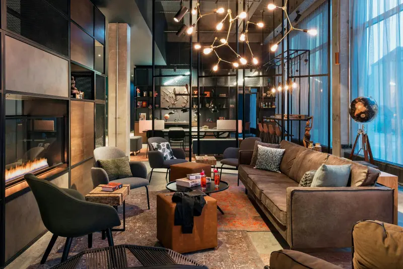 Un espace de détente intérieur avec des canapés, des fauteuils et une cheminée.