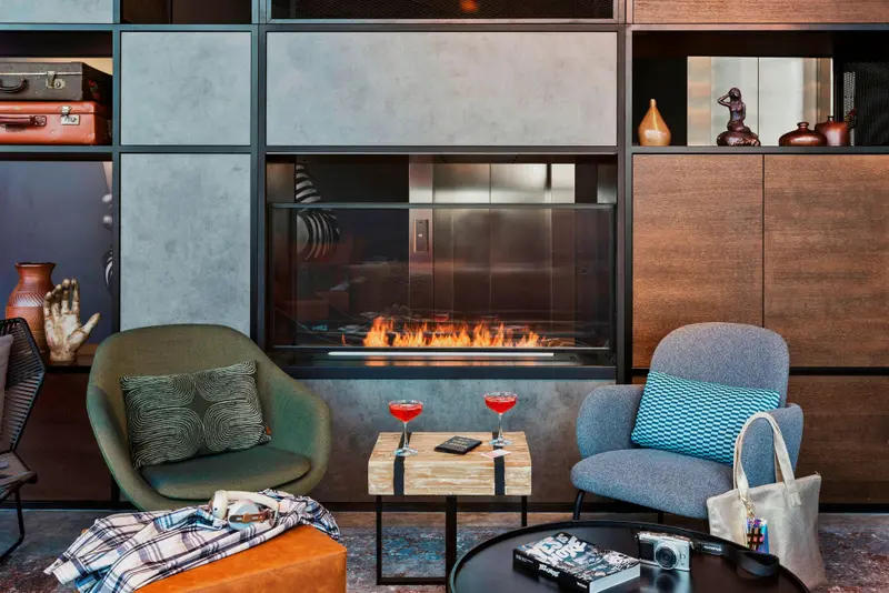 Un salon chaleureux avec une cheminée moderne et des fauteuils confortables.