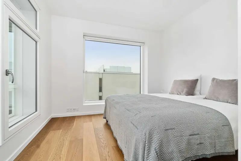 Une chambre lumineuse avec un lit recouvert d'une couverture à motifs.