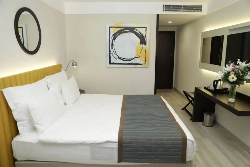 Une chambre lumineuse avec un grand lit et une décoration sobre.