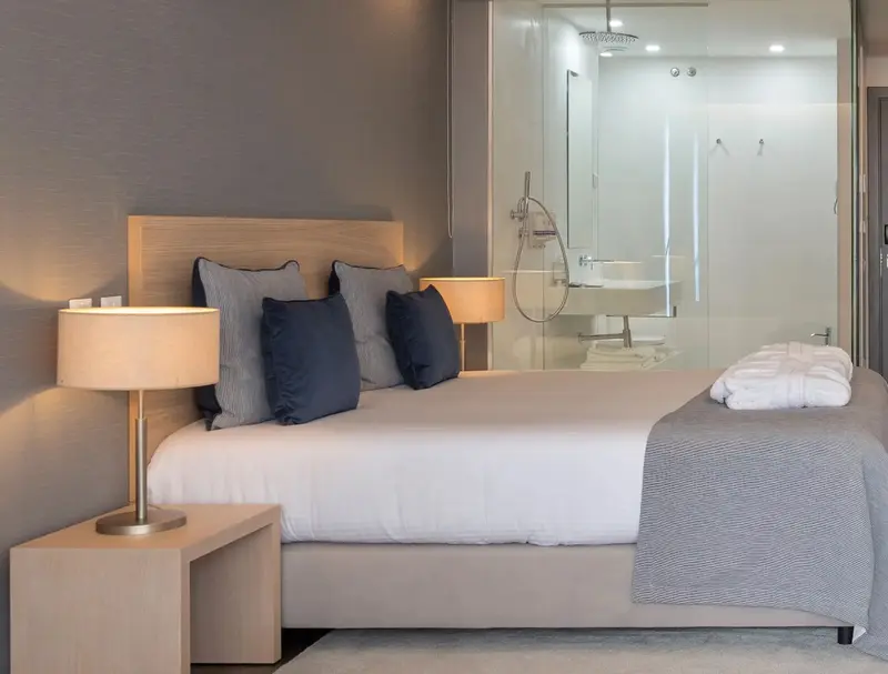 Un lit confortable avec des oreillers bleus dans une chambre lumineuse.