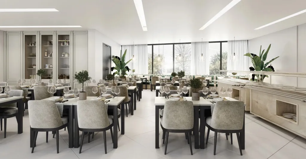 Une salle lumineuse avec des tables dressées pour un repas.