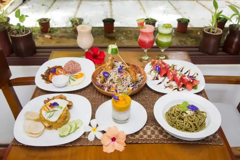 Une table dressée présente une variété de plats colorés et de boissons fraîches.