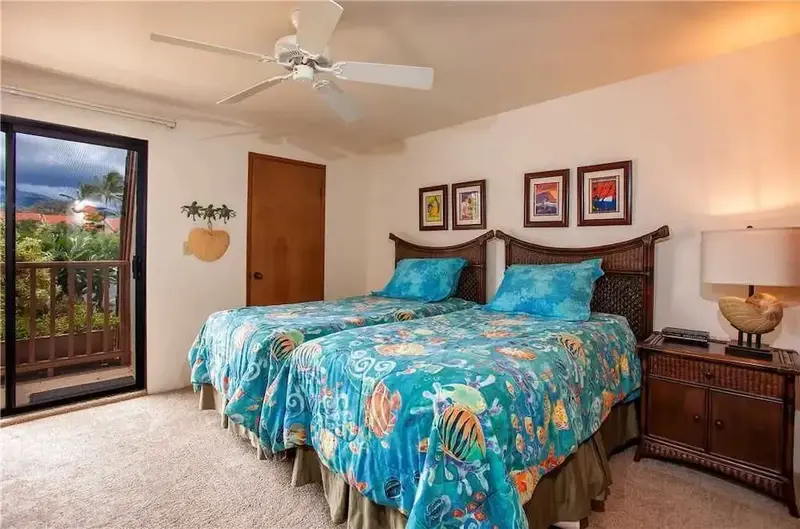 Une chambre lumineuse avec deux lits simples et une décoration tropicale.