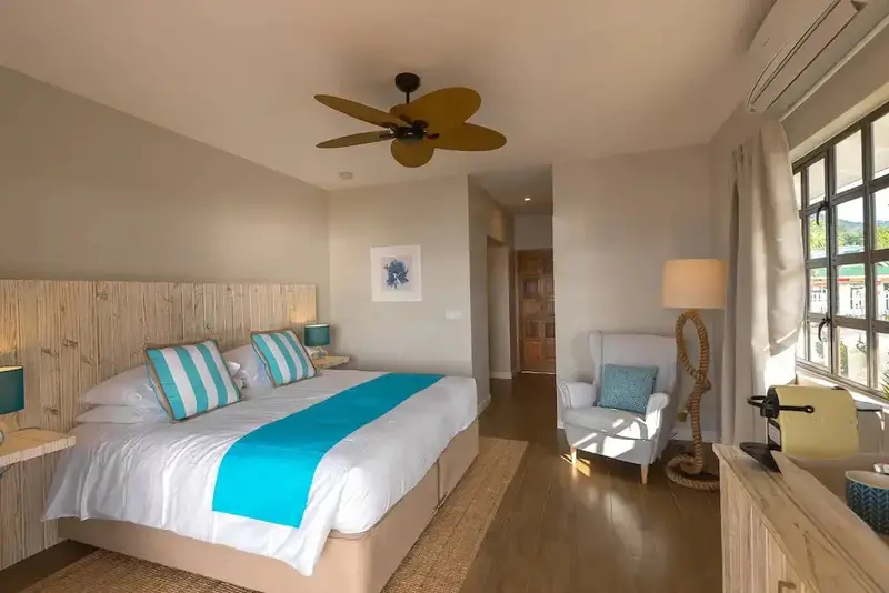 Une chambre lumineuse avec un grand lit et un fauteuil.