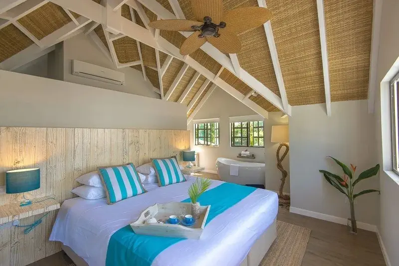 Une chambre lumineuse avec un grand lit et une baignoire.