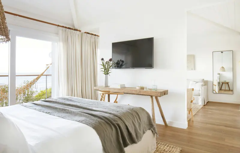 Une chambre lumineuse avec un grand lit et une vue sur la mer.