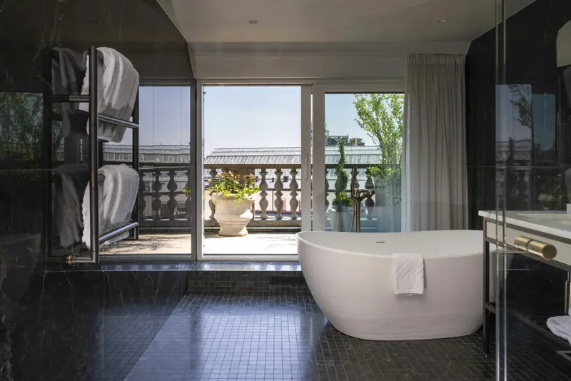 Une salle de bain moderne avec une baignoire et un accès à une terrasse.