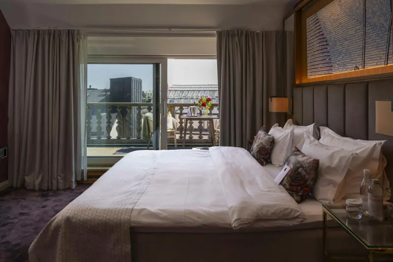 Une chambre lumineuse avec un grand lit et un accès à une terrasse.