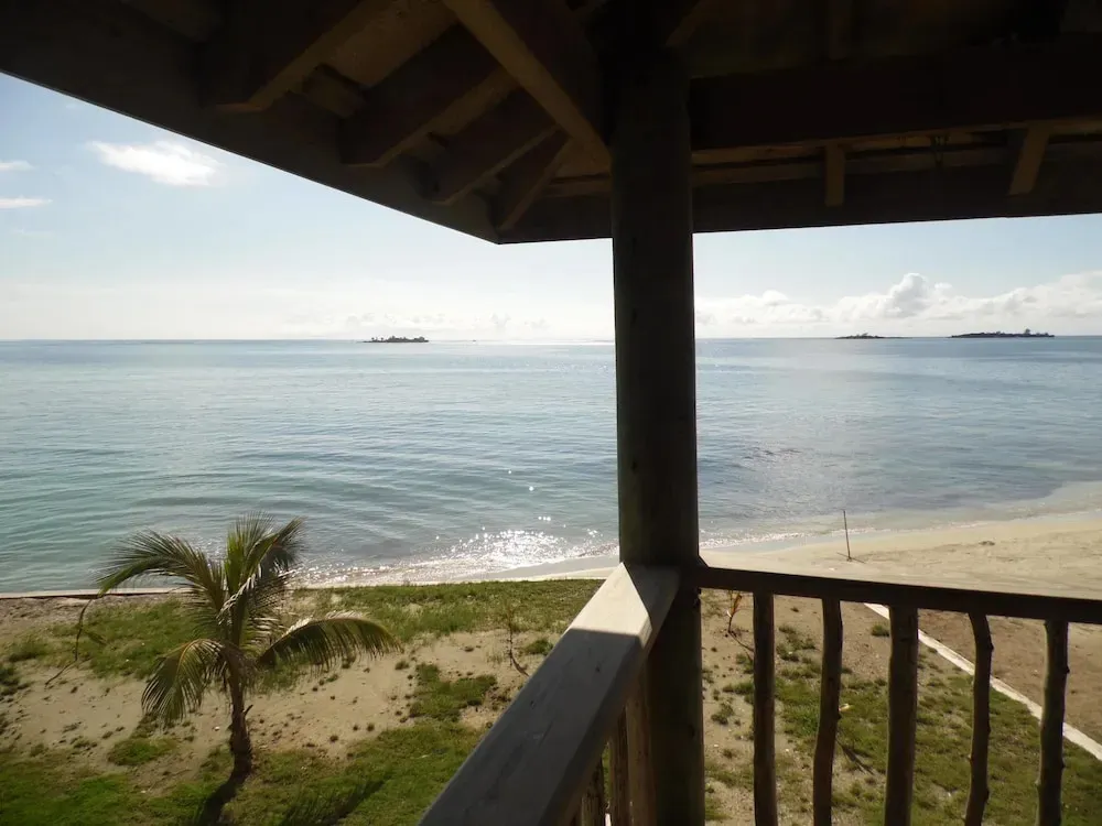 Vue sur la mer depuis une terrasse ombragée.
