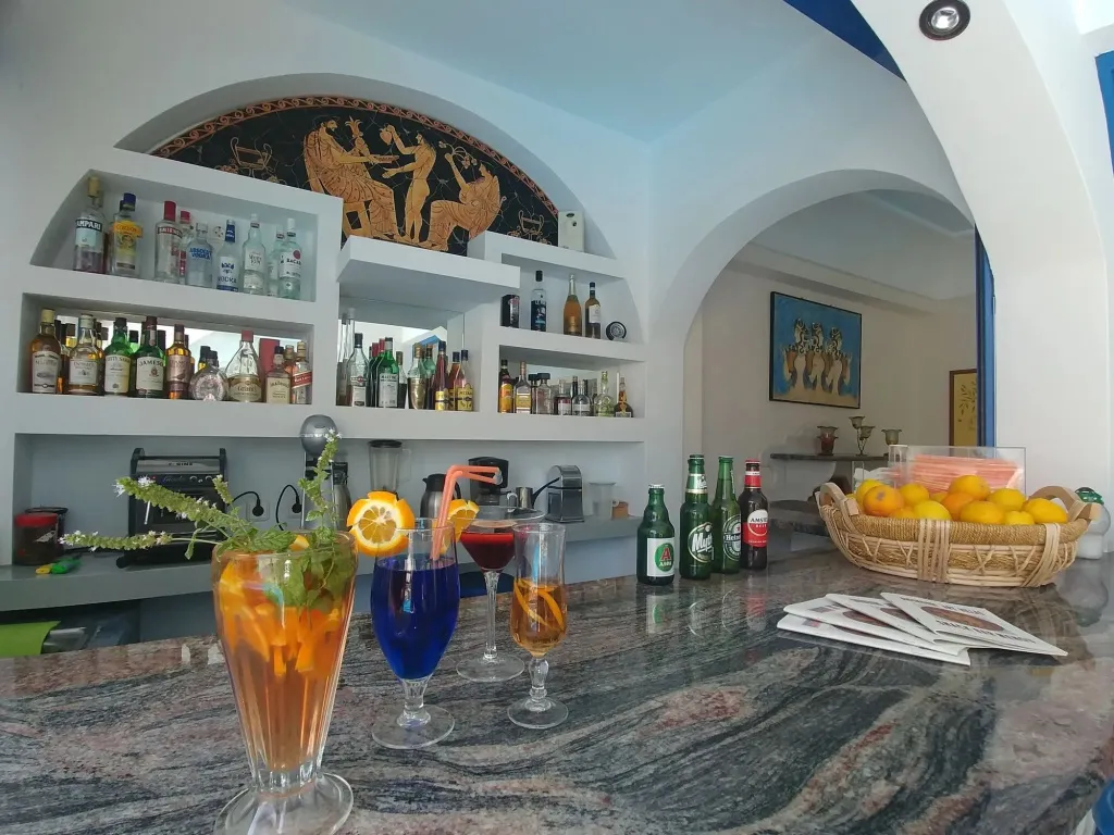 Un comptoir de bar présente des boissons colorées et des bouteilles d'alcool.