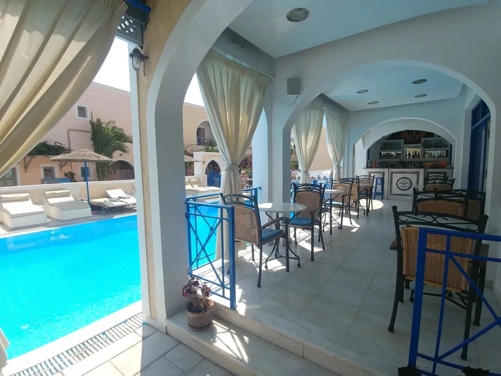 Espace de détente avec piscine et bar en arrière-plan.